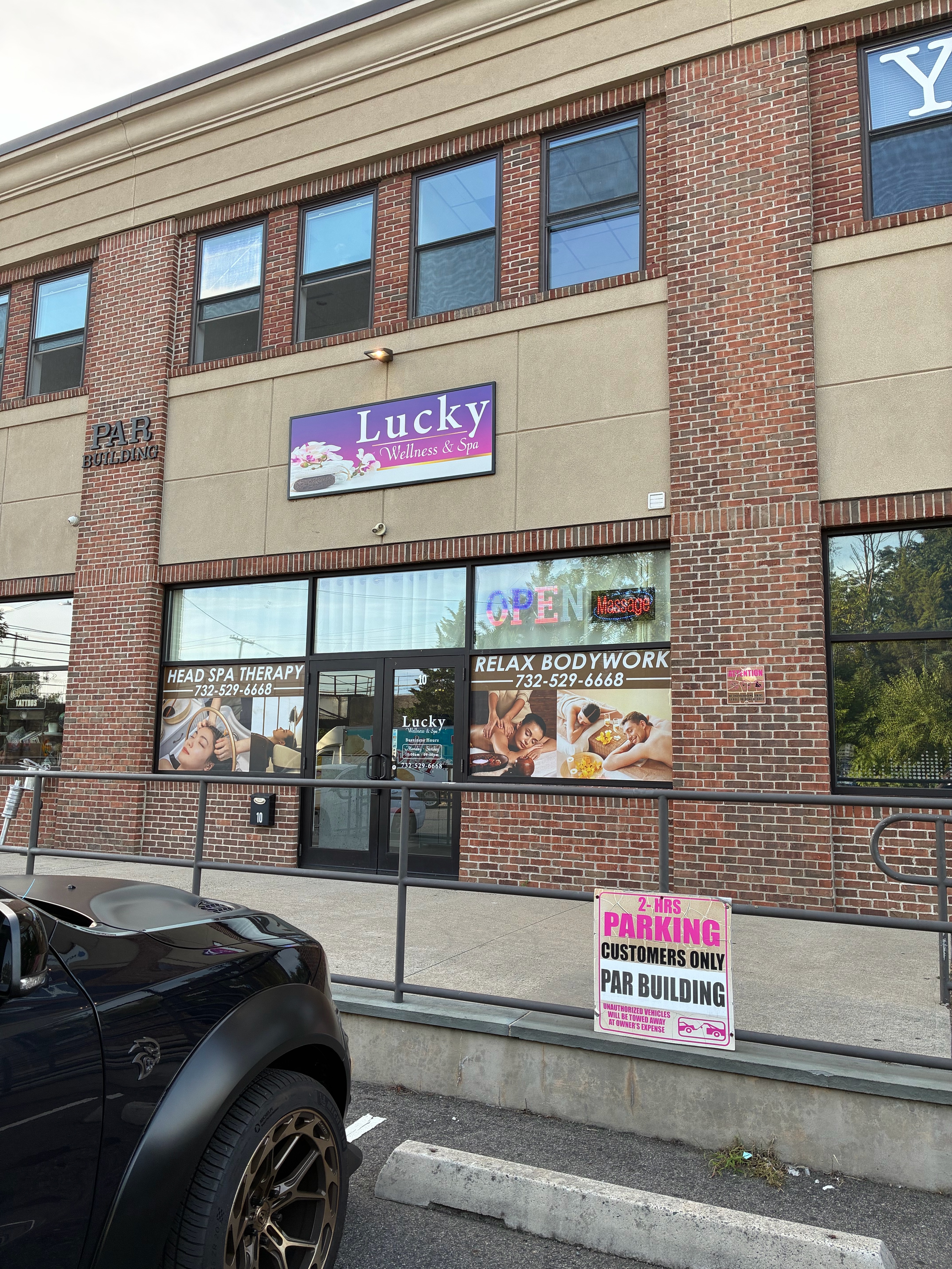 Lucky Wellness & Spa storefront with parking and business hours signage